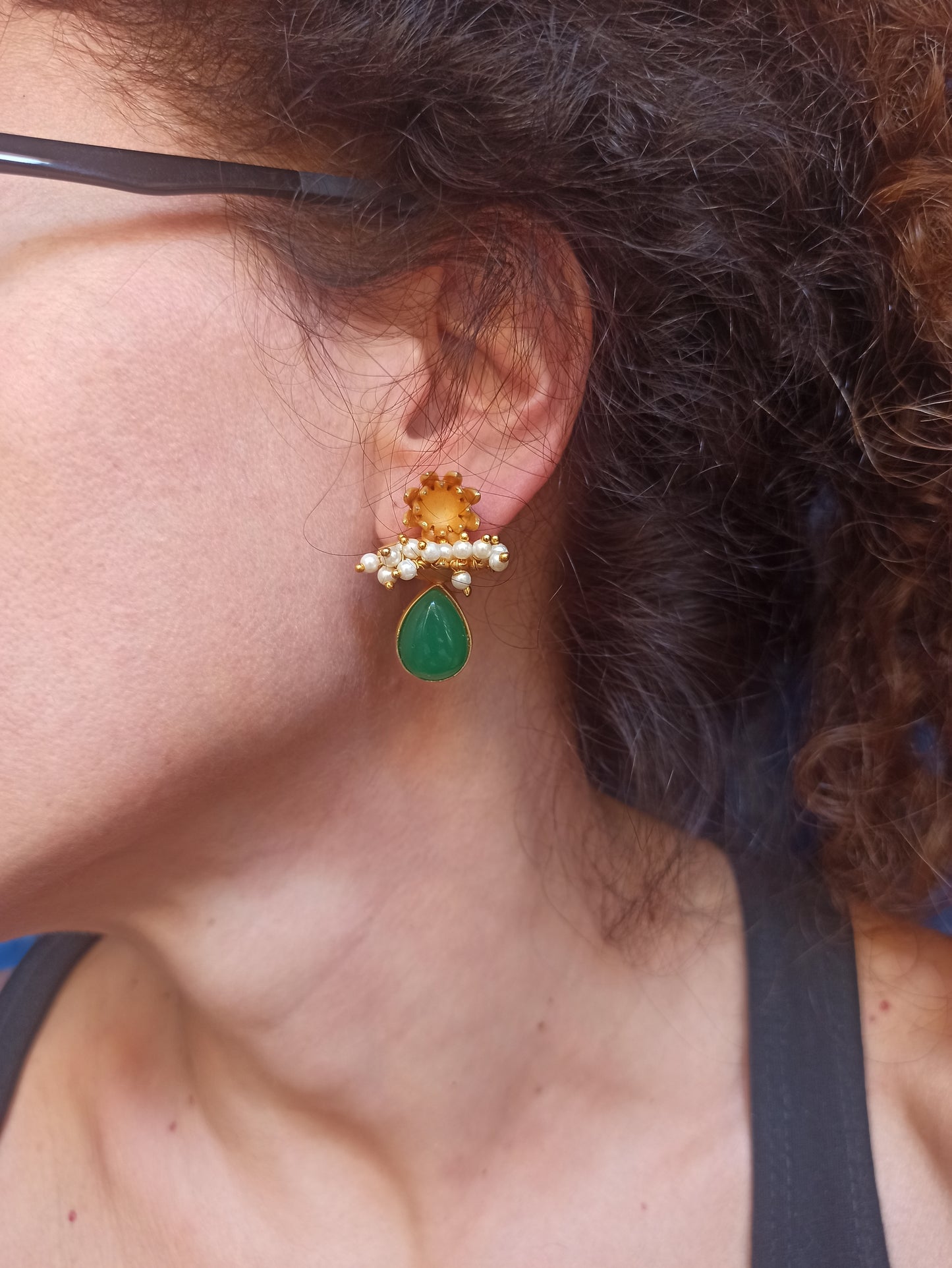 Goldene Ohrringe mit grünen Perlen
