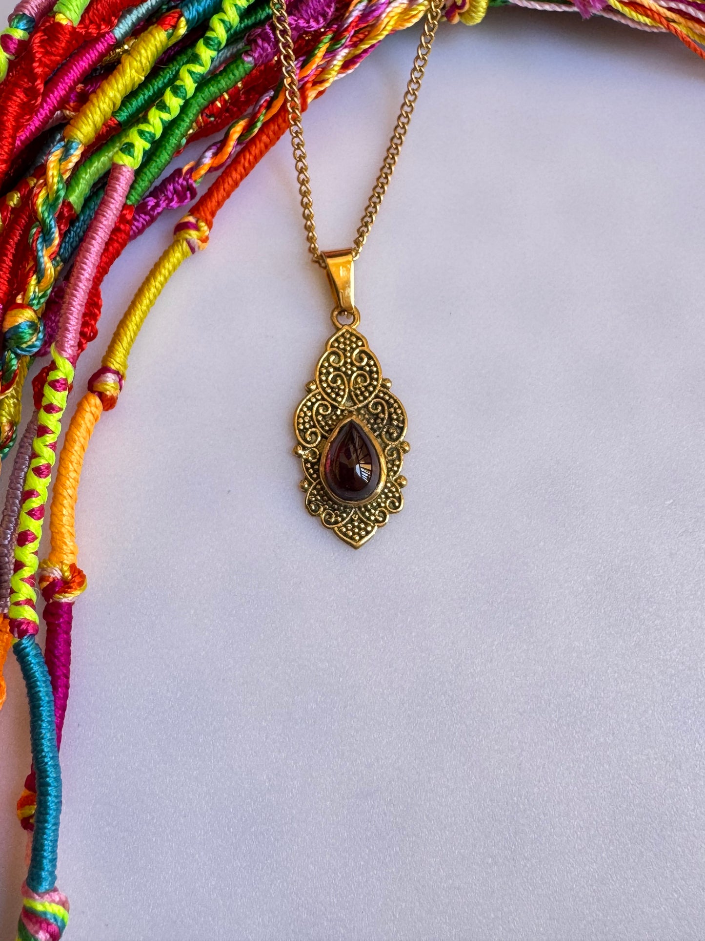 Golden necklace with red pendant