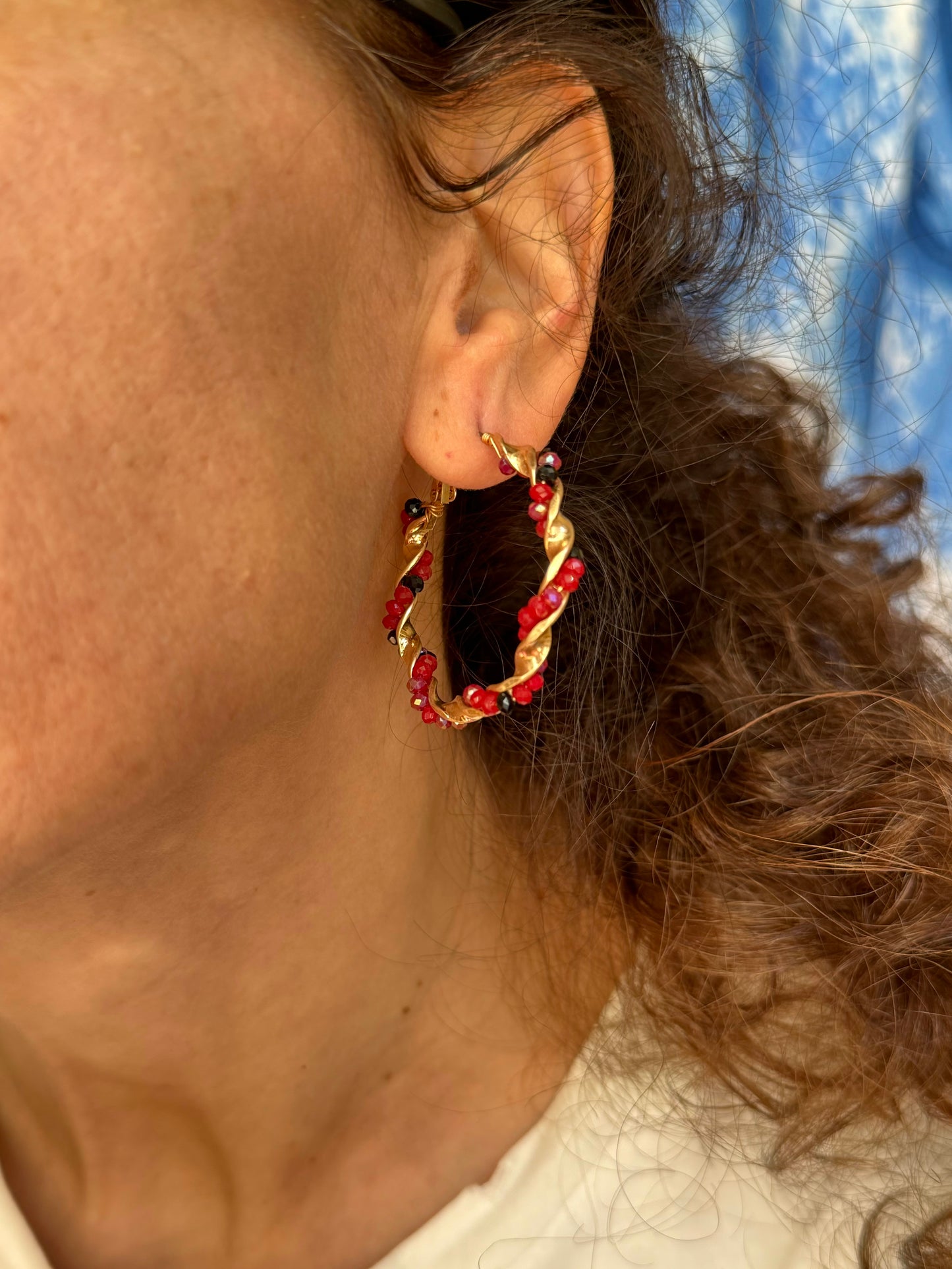 Golden earrings with red beaded circles