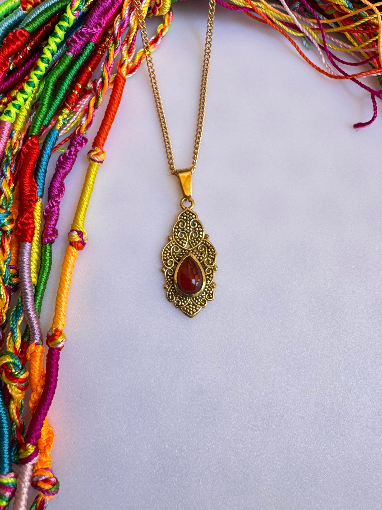 Golden necklace with red pendant