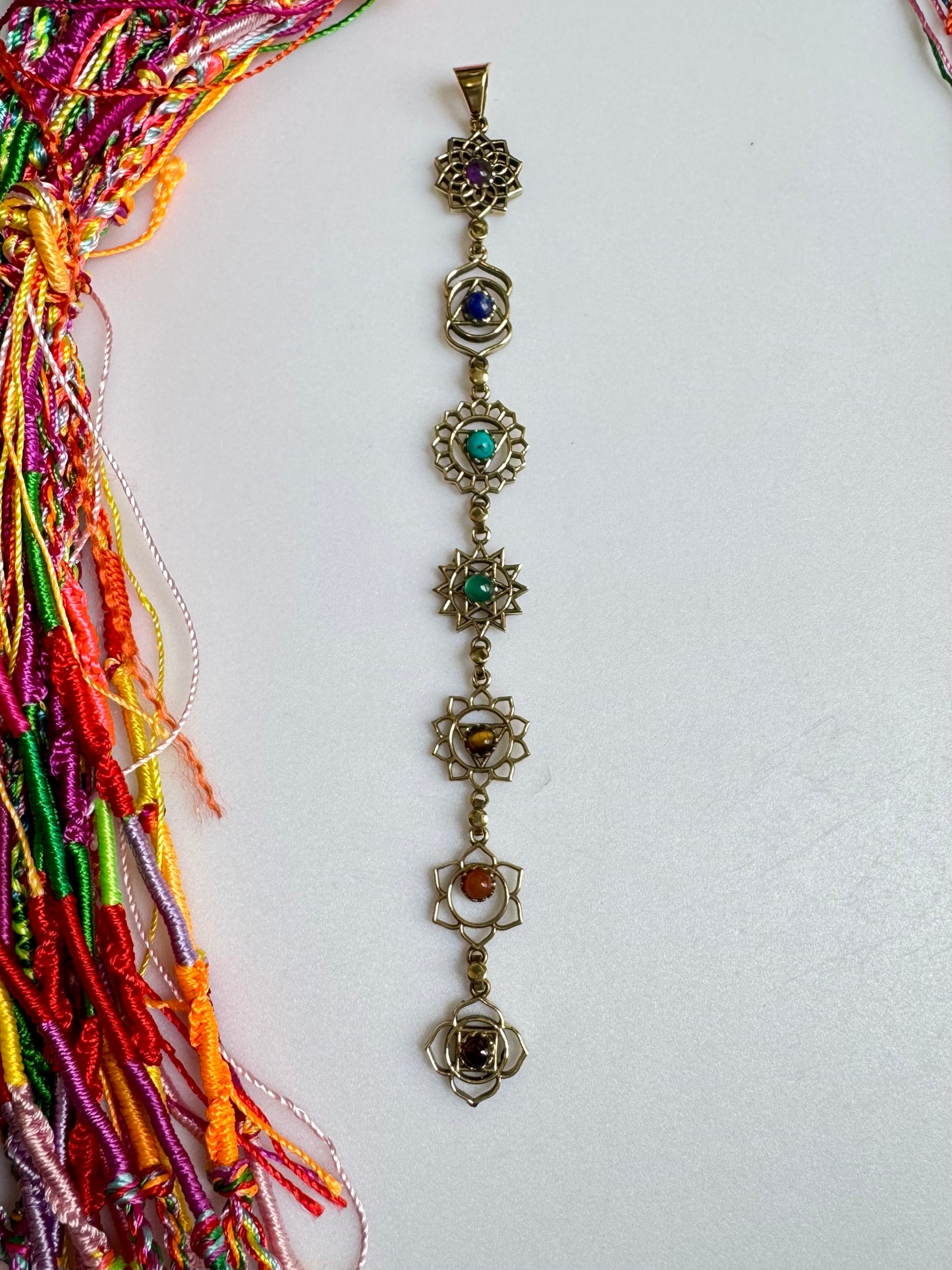 Collana dorata con ciondolo simboli e colori sette chakra