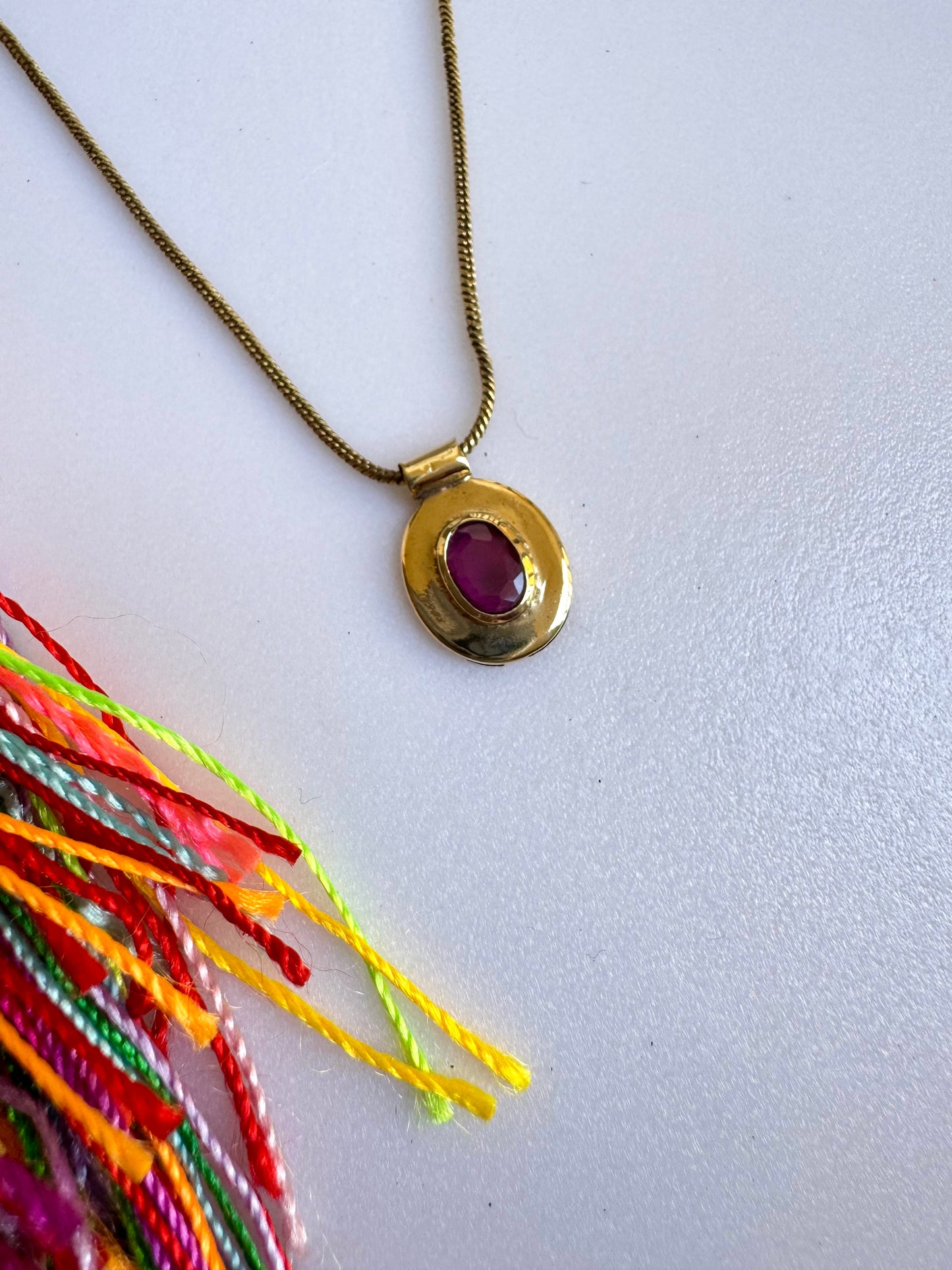 Collana dorata con ciondolo rosso