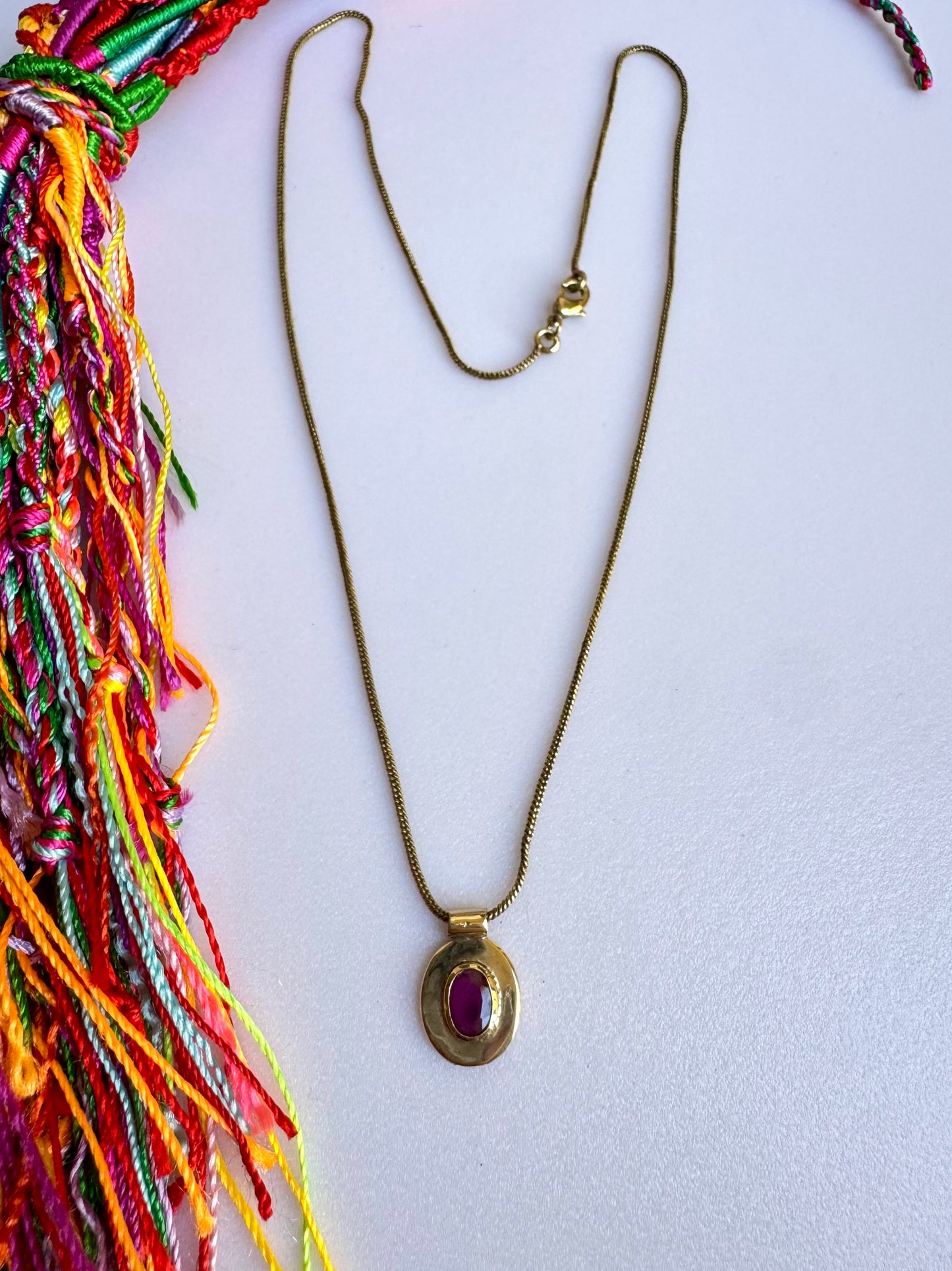 Collana dorata con ciondolo rosso