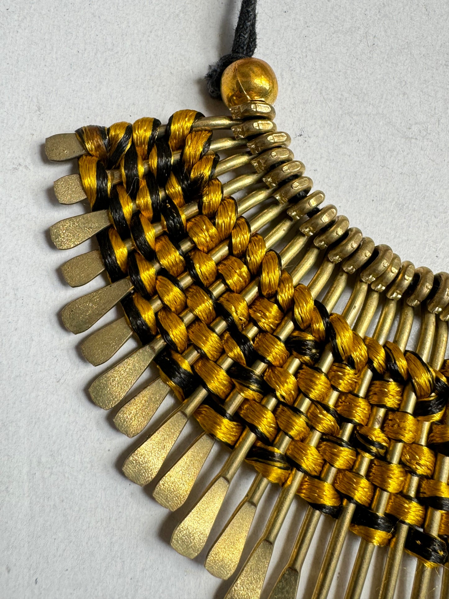 Golden bib necklace with colored threads