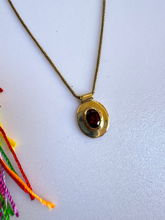 Collana dorata con ciondolo rosso