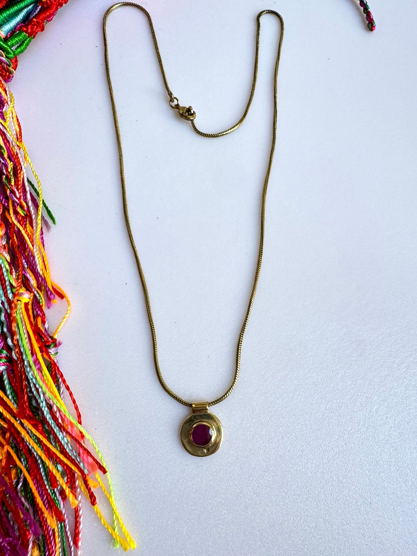 Collana dorata con ciondolo rosso