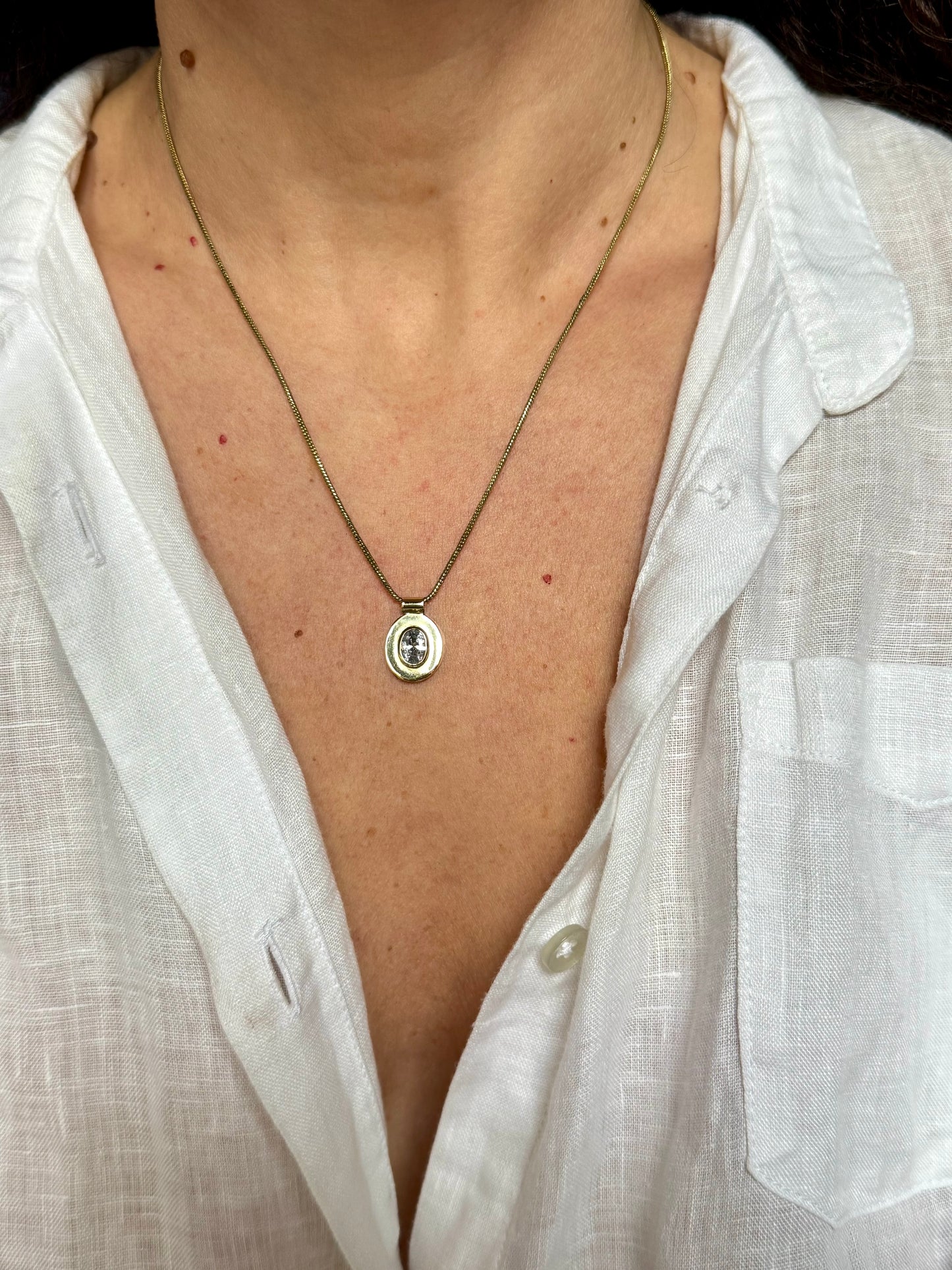 Collana dorata con ciondolo bianco