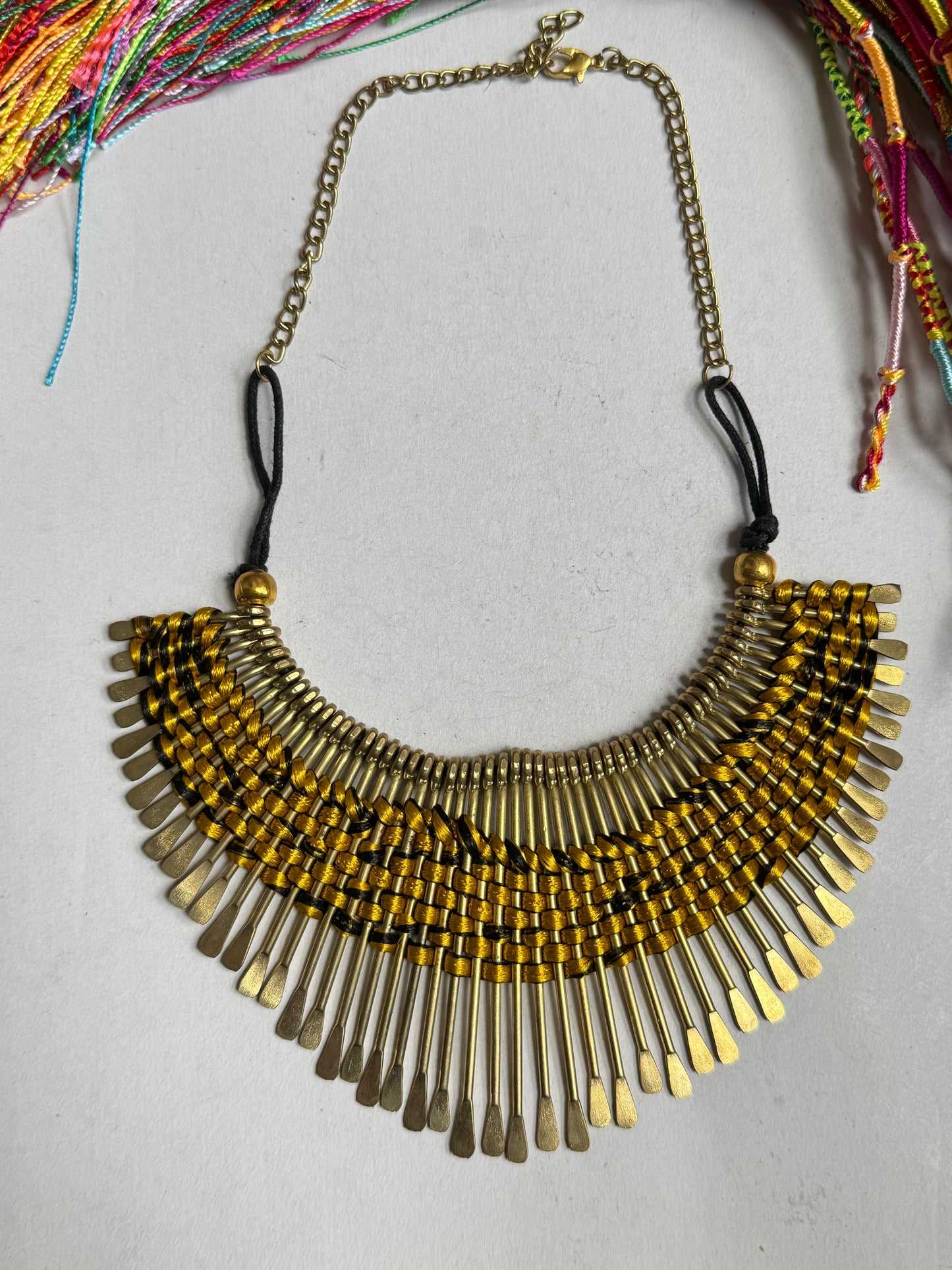 Golden bib necklace with colored threads