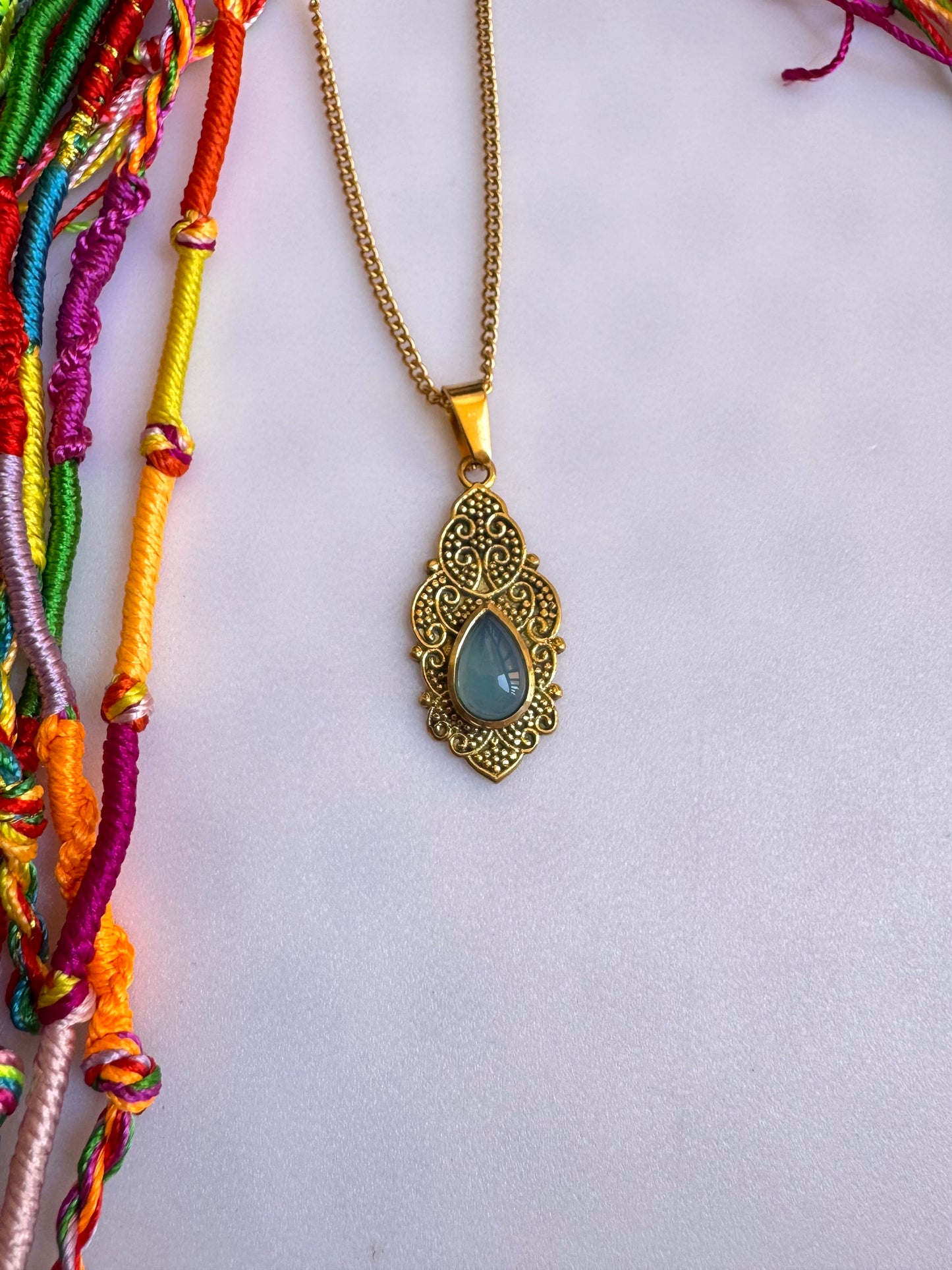 Golden necklace with light blue pendant