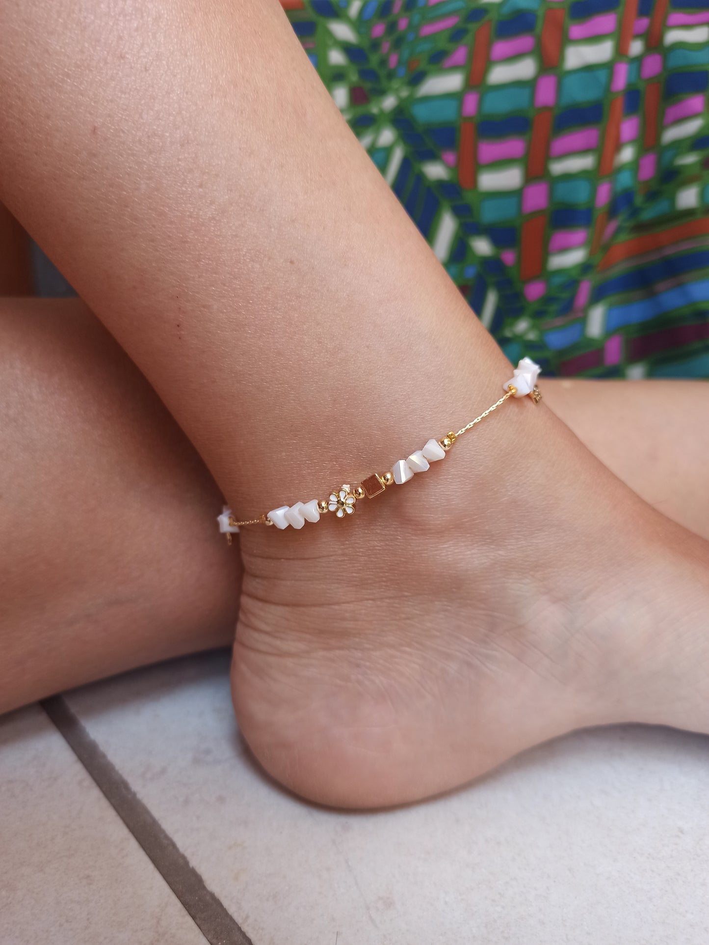 Golden anklet with white flower