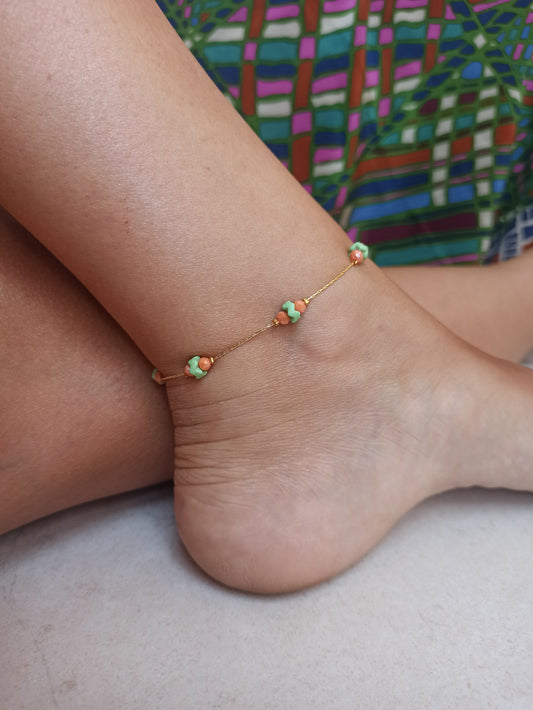 Golden anklet with green and orange decoration