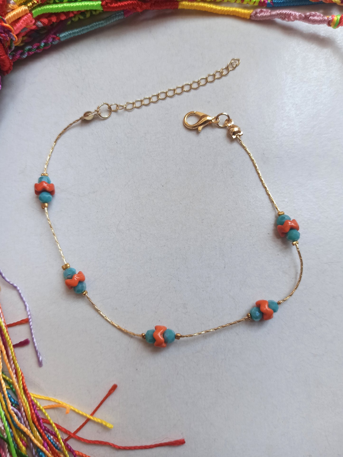 Golden anklet with turquoise and orange decoration