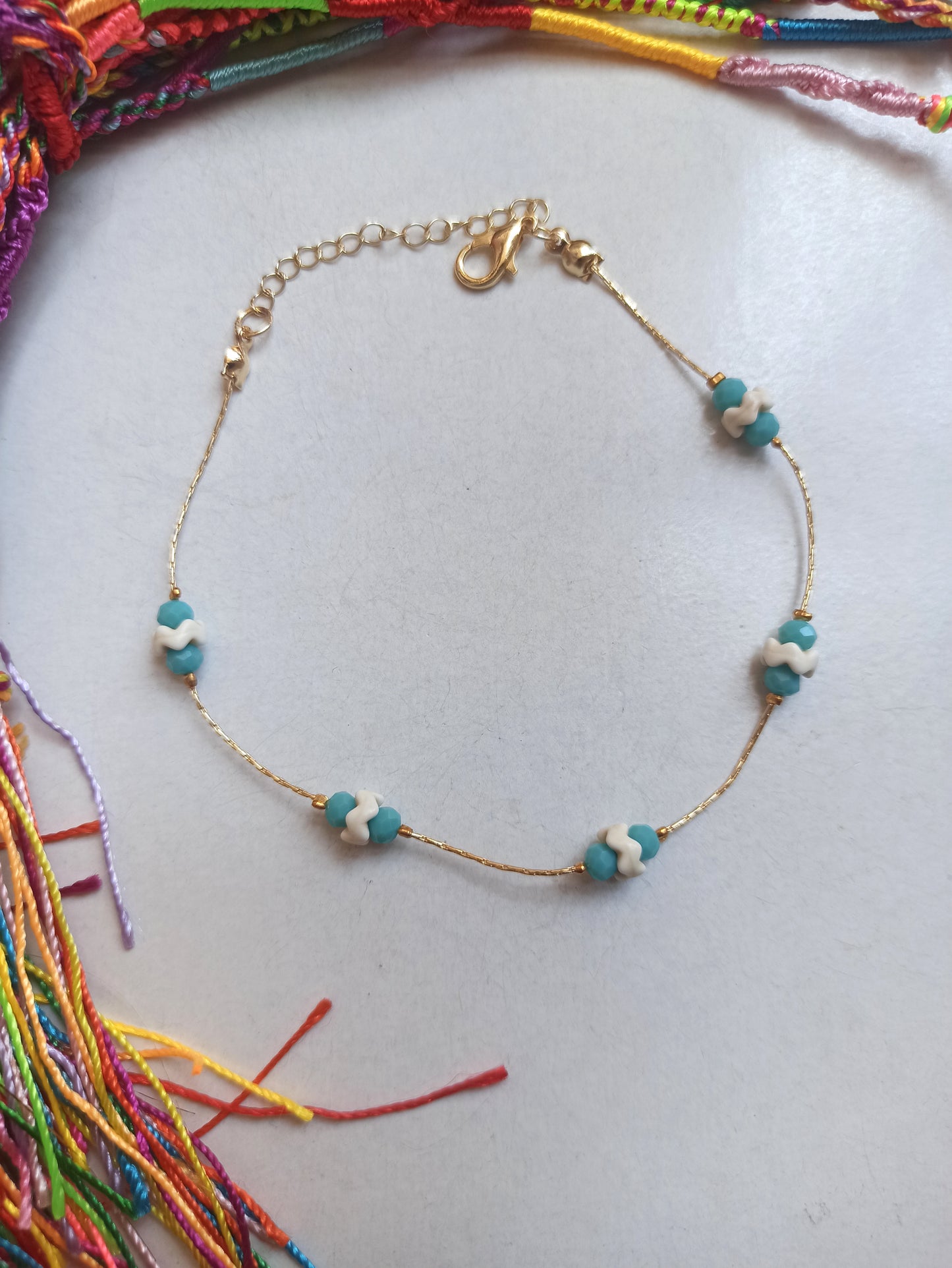 Golden anklet with turquoise and white decoration