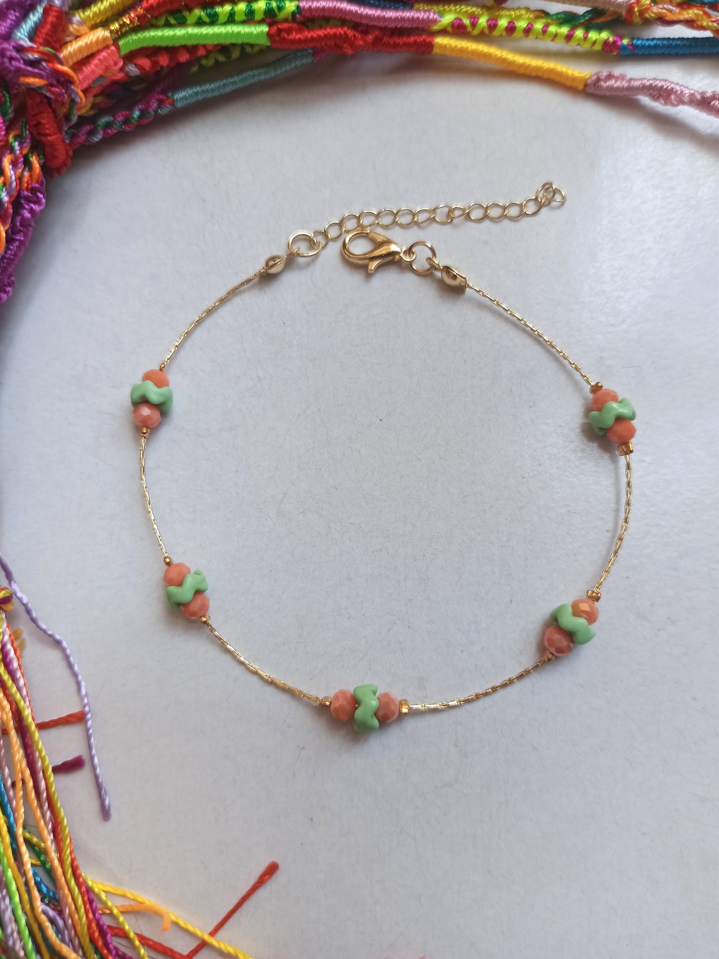 Golden anklet with green and orange decoration