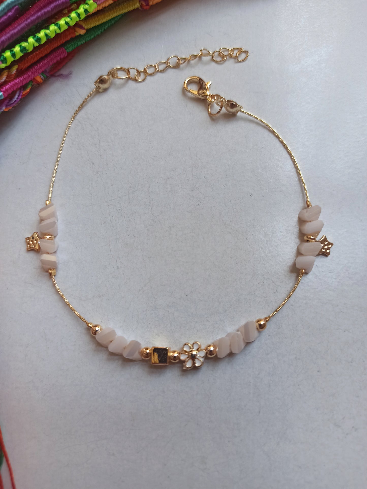 Golden anklet with white flower