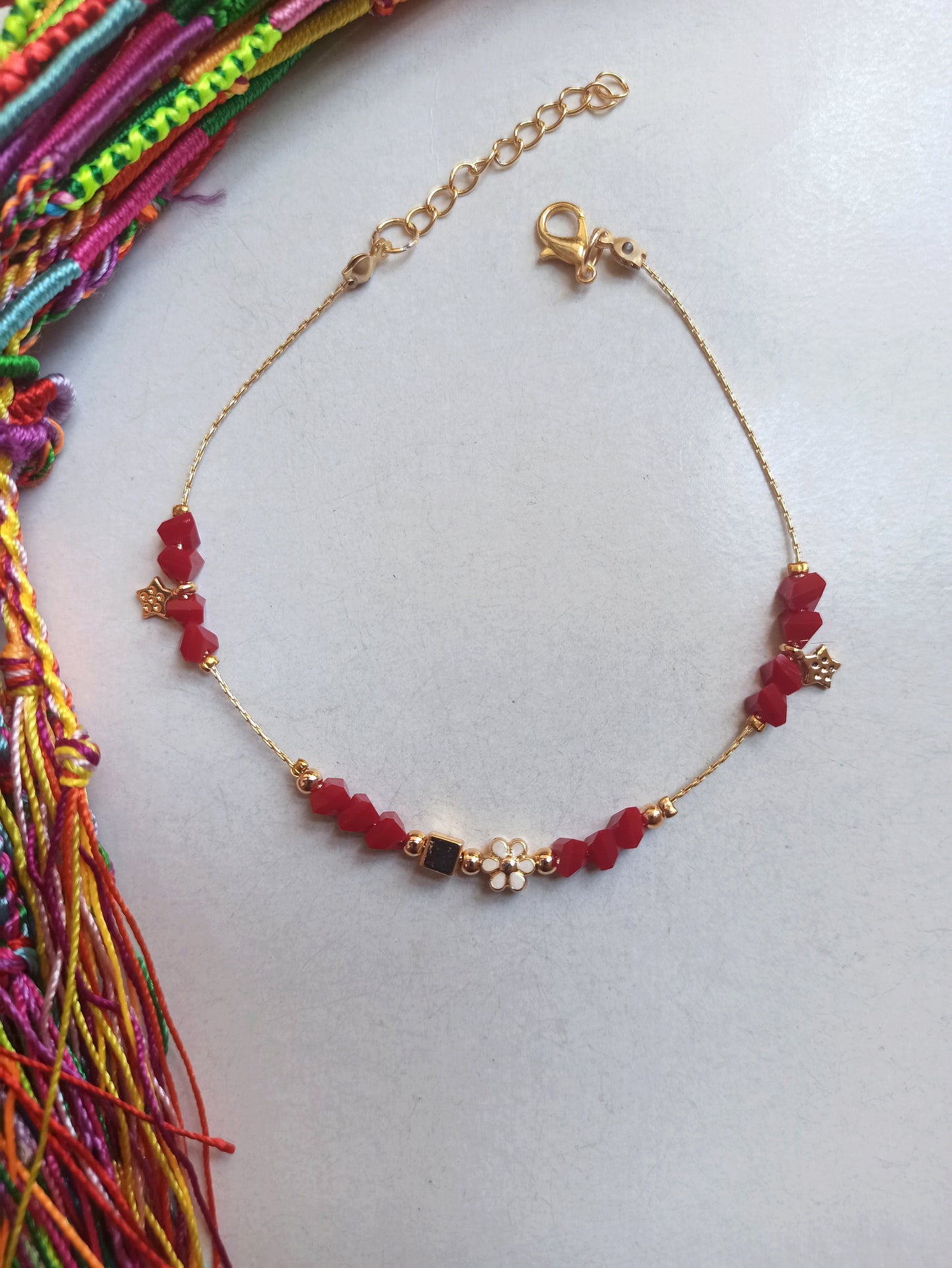 Golden anklet with red flower