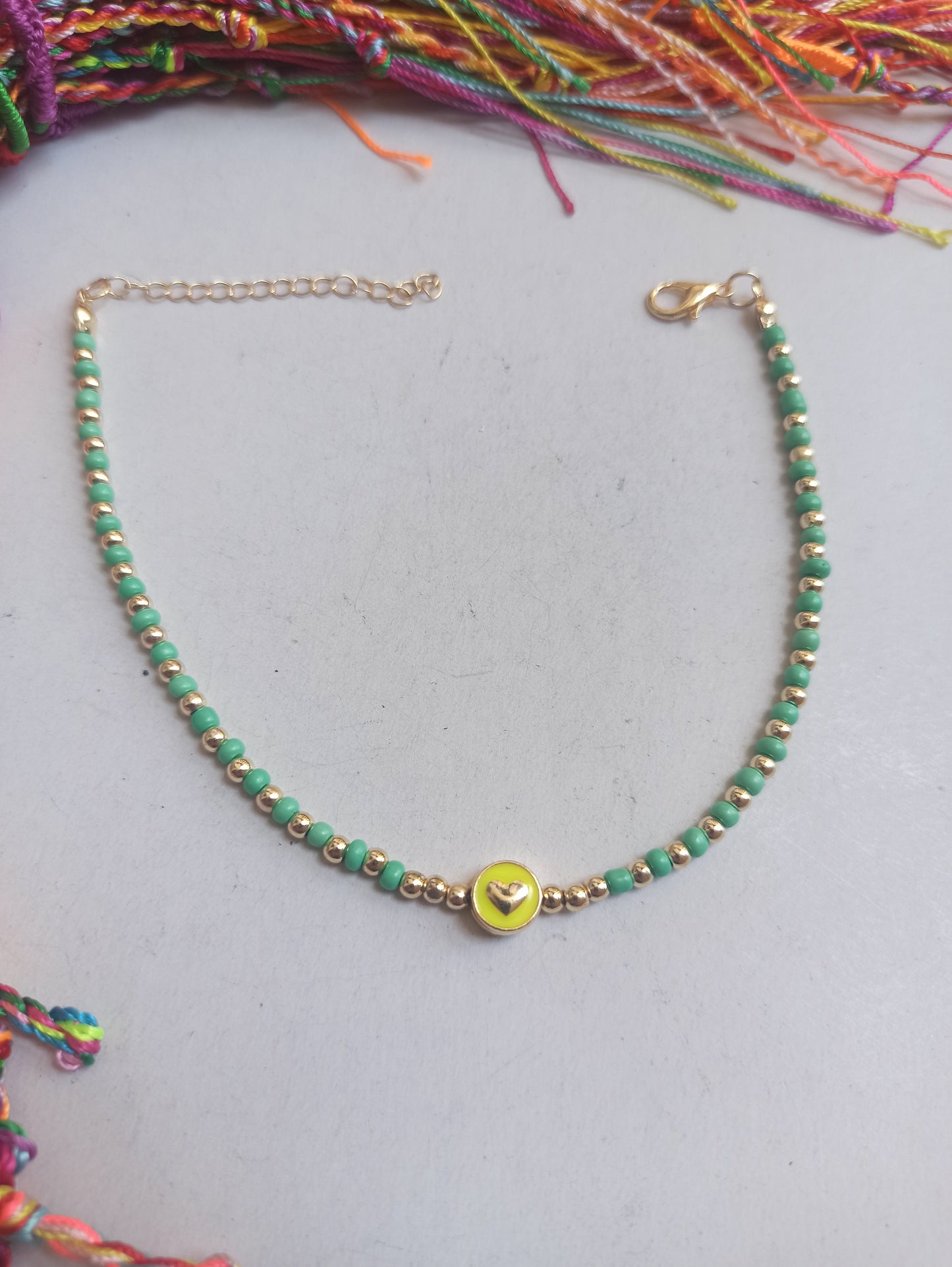 Golden anklet with green beaded heart