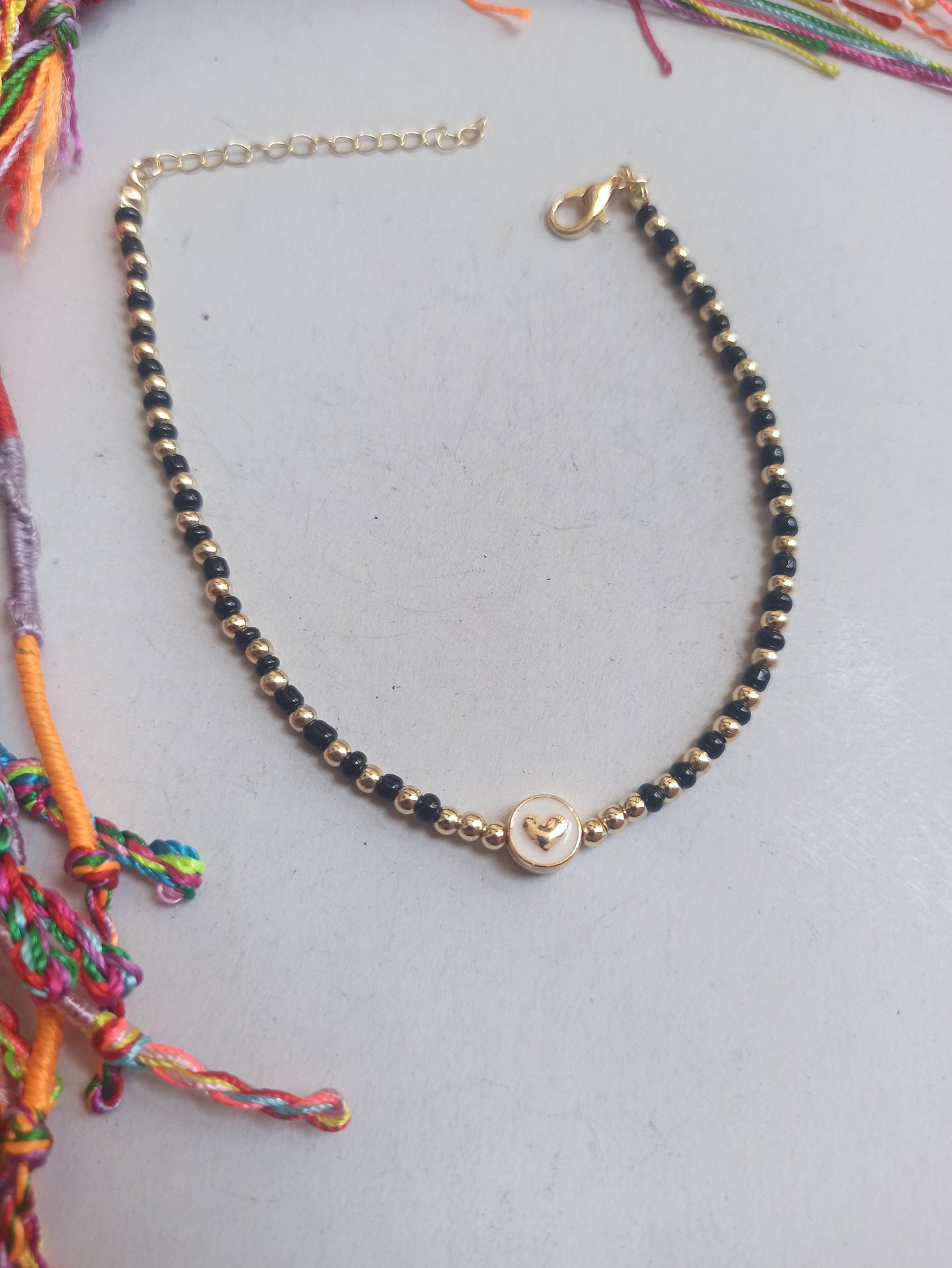 Golden anklet with black beaded heart