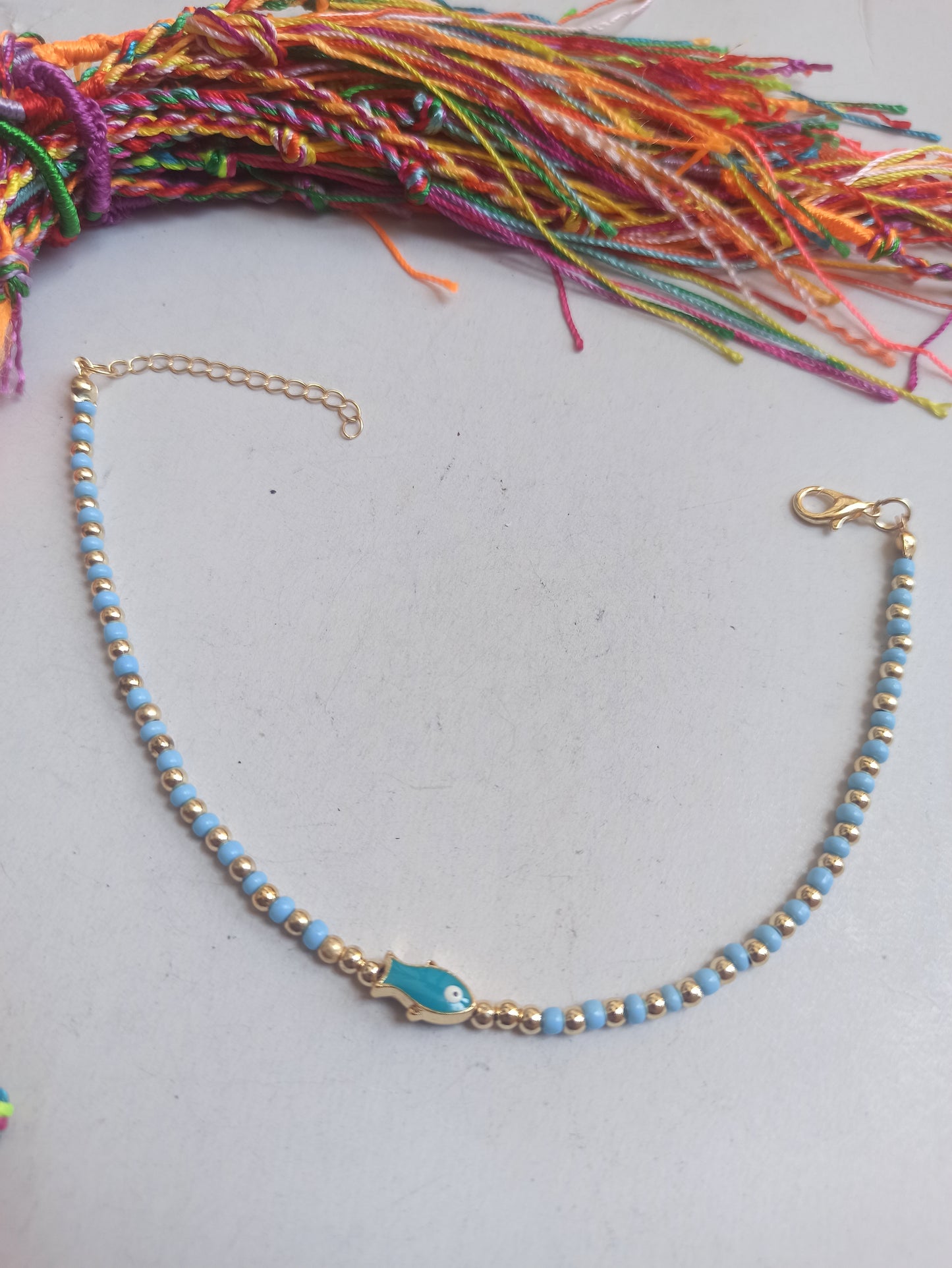 Golden fish anklet with light blue beads