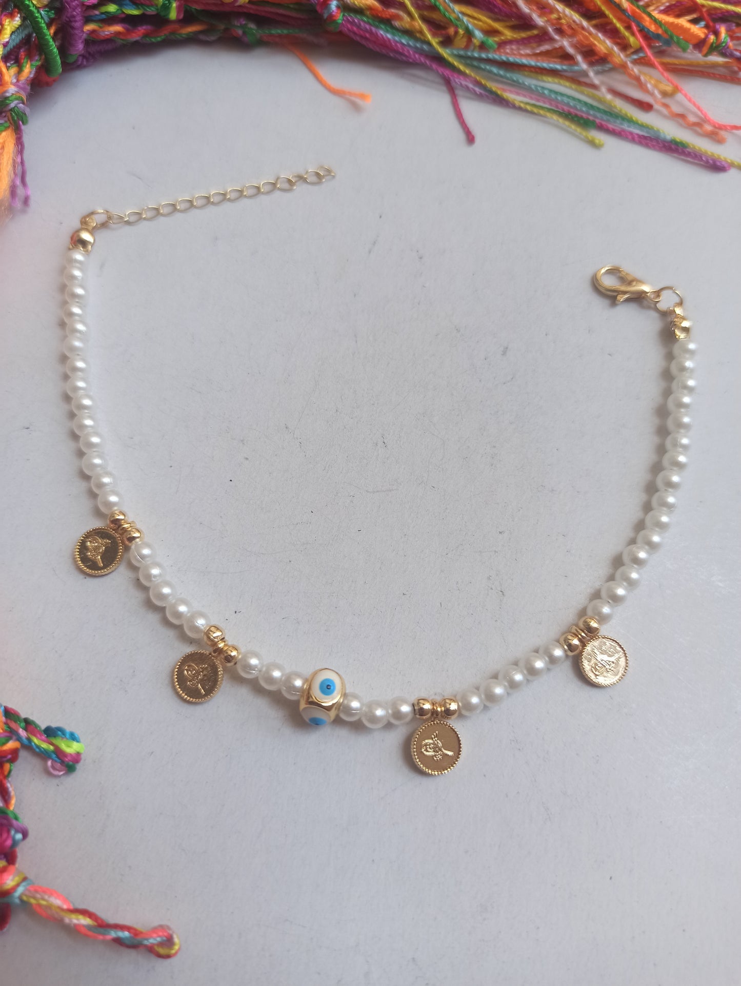 Golden anklet with white beaded eye