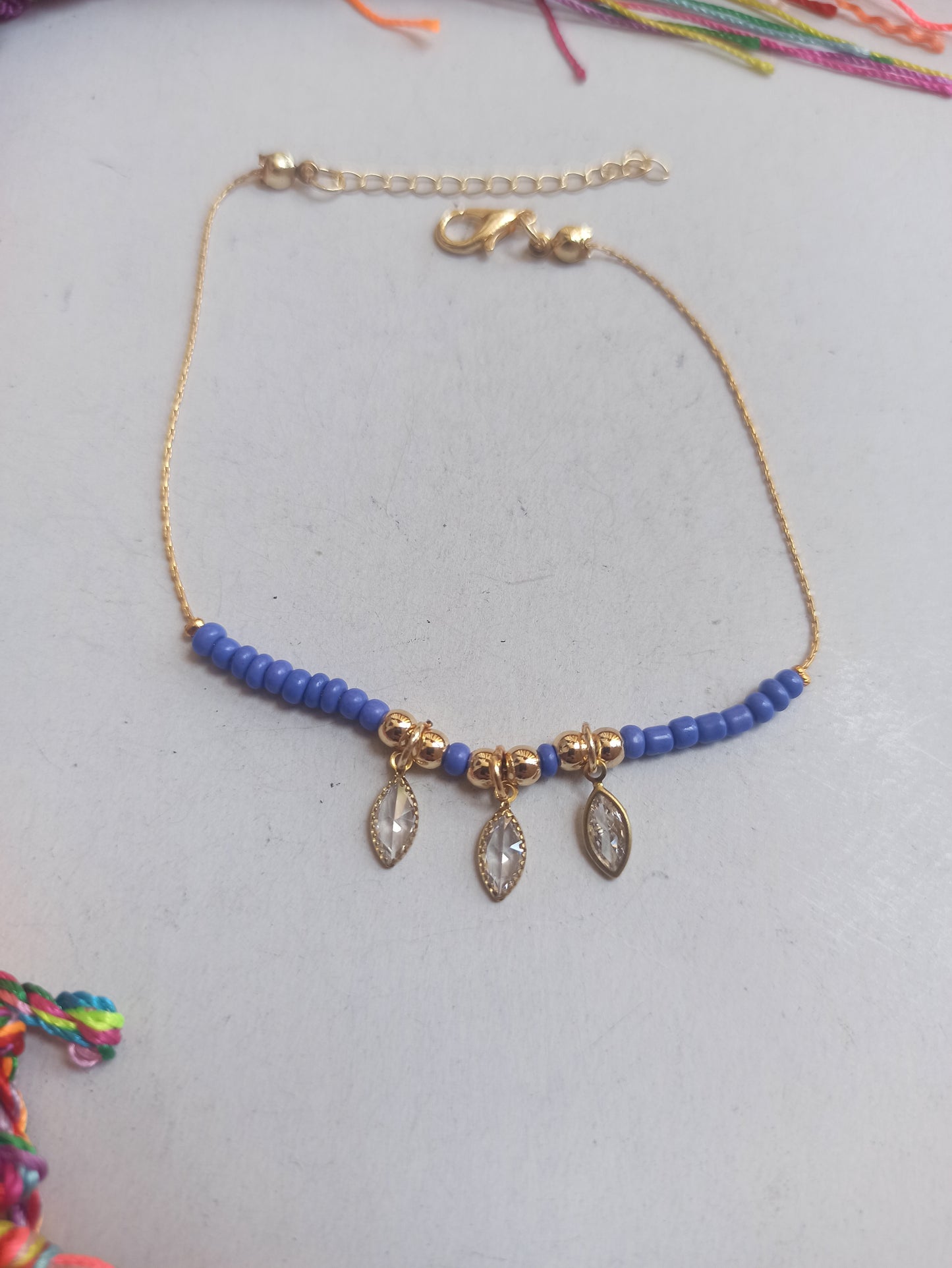 Golden anklet with 3 light blue beads