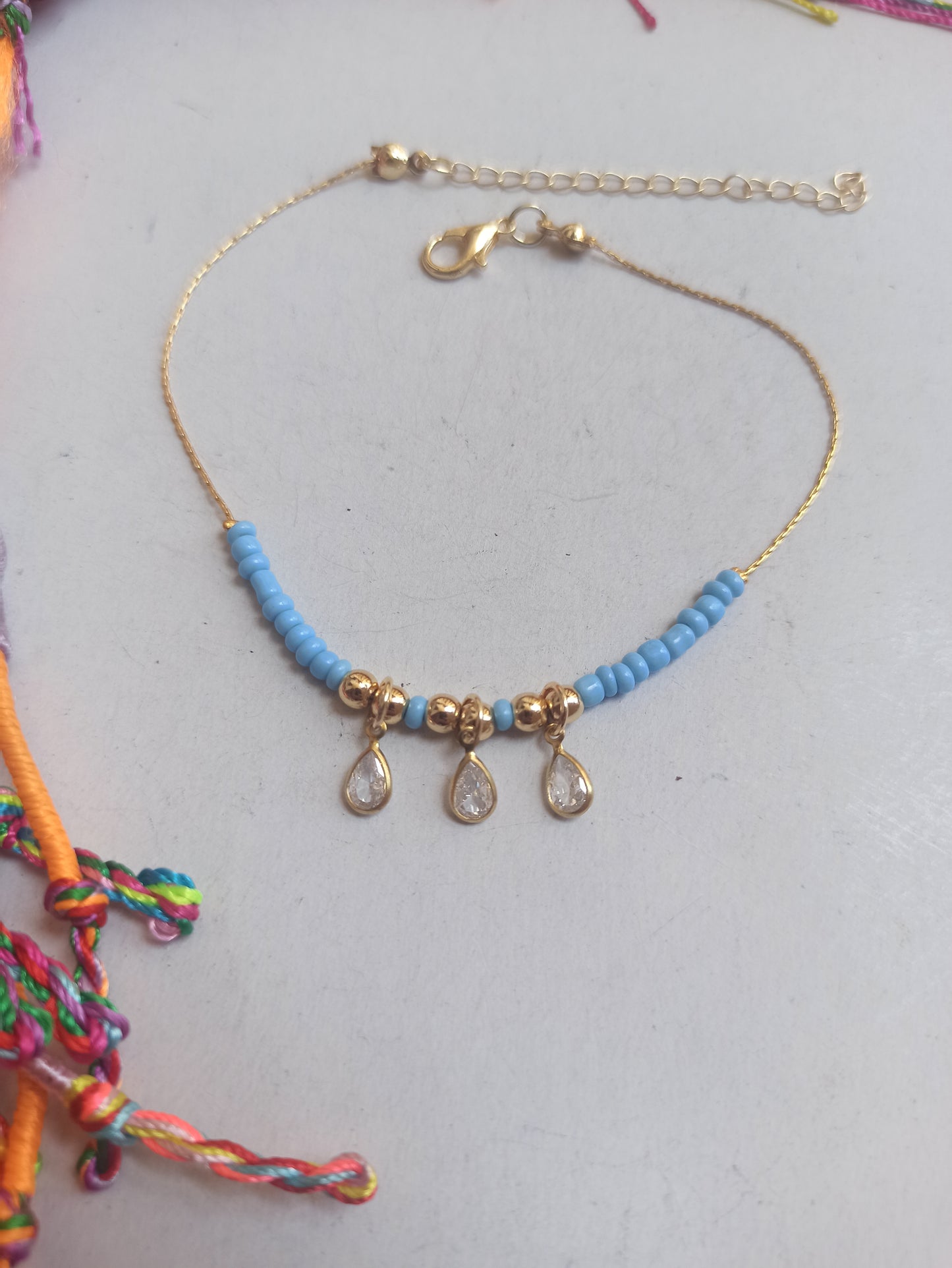 Golden anklet with 3 light blue beads