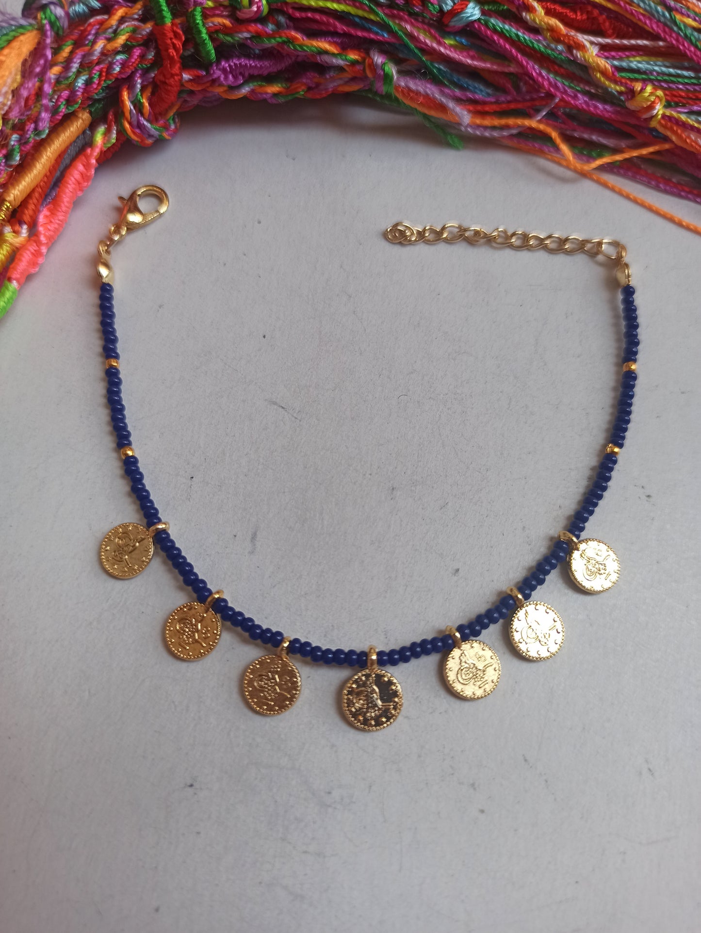 Thin beaded bracelet with blue coins