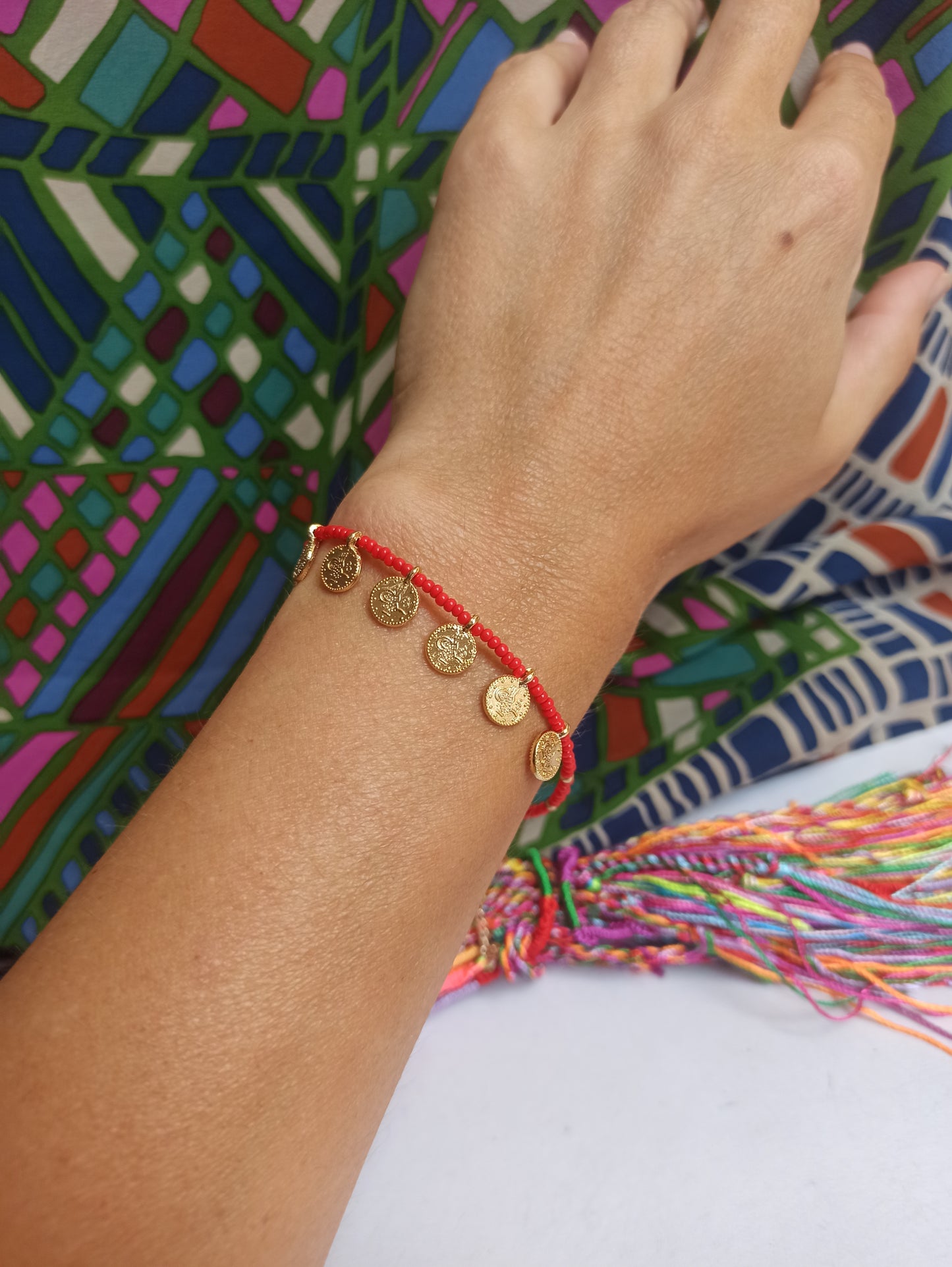 Thin beaded bracelet with red coins