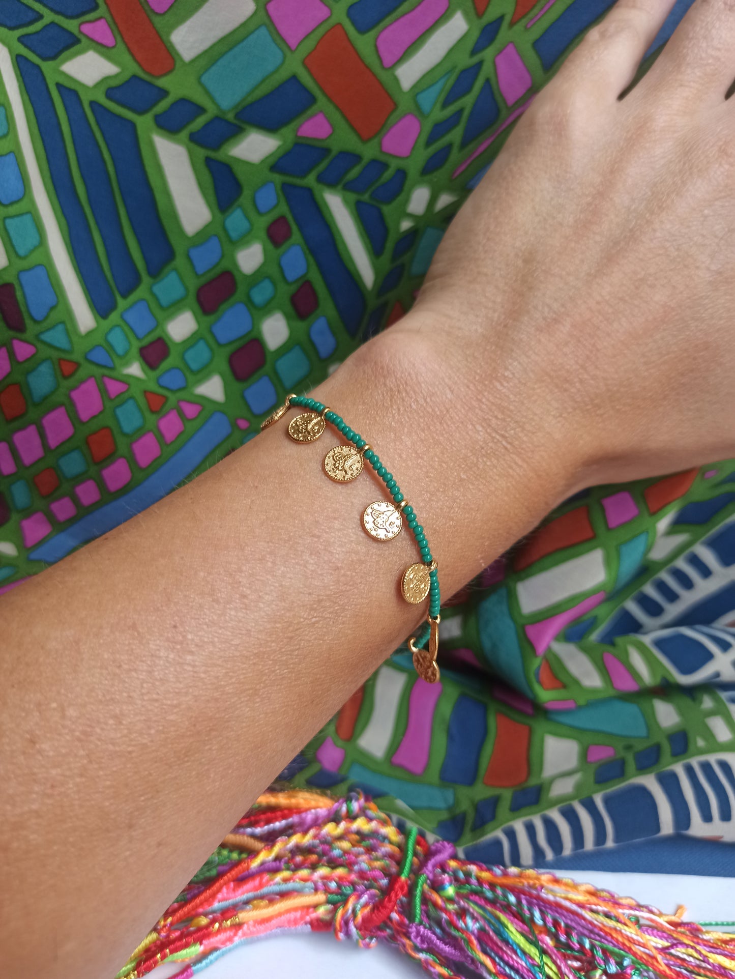 Thin beaded bracelet with green coins