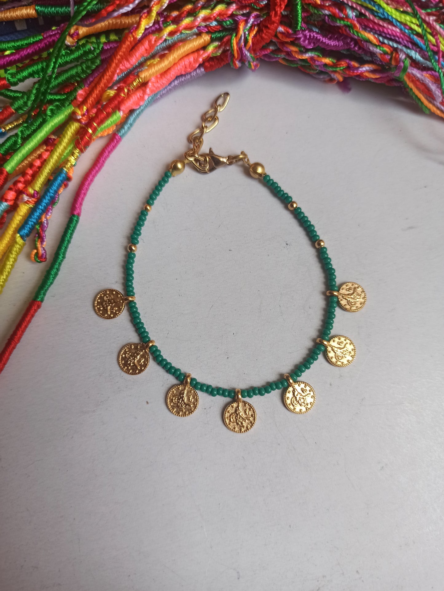 Thin beaded bracelet with green coins