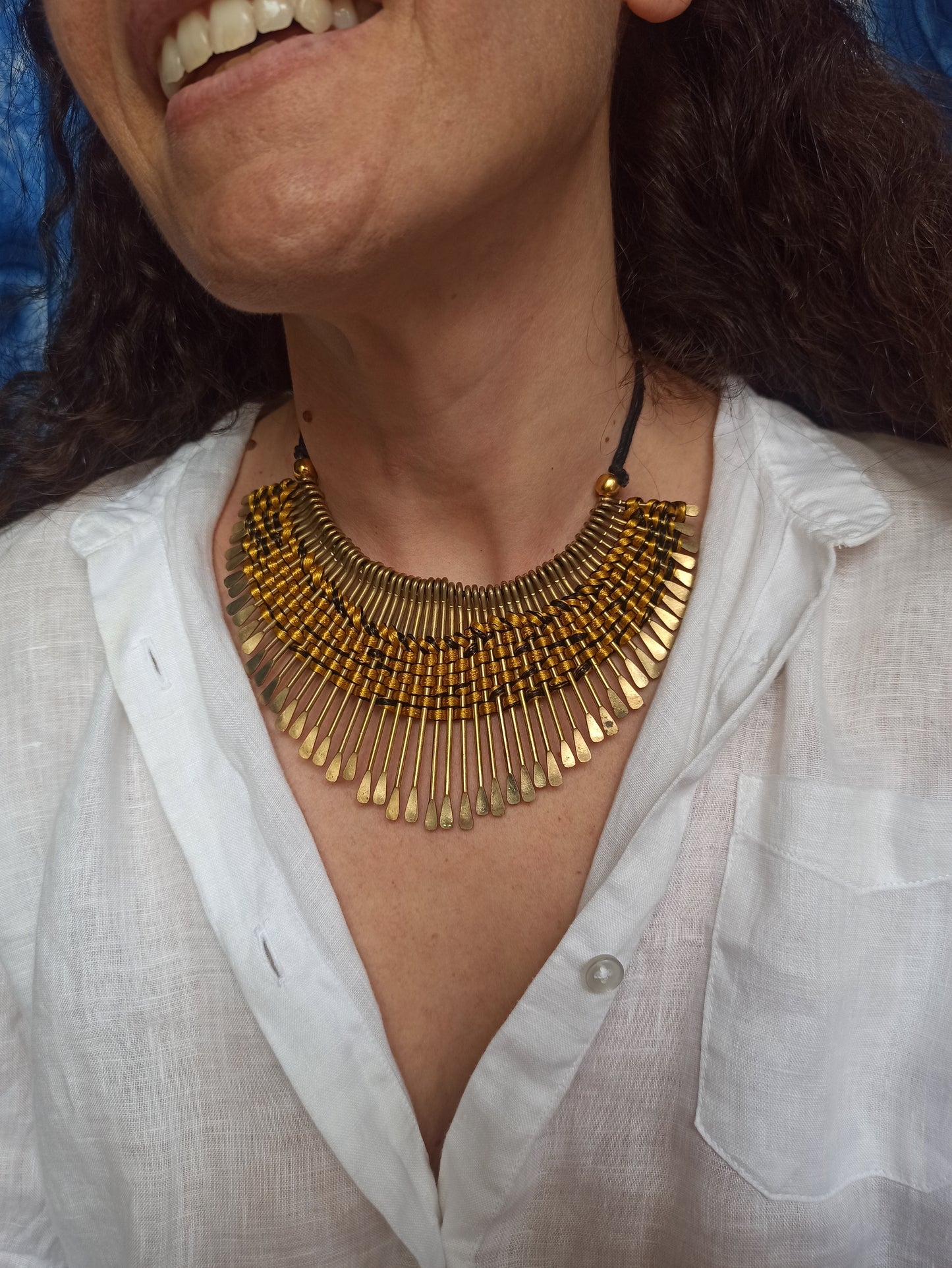 Golden bib necklace with colored threads