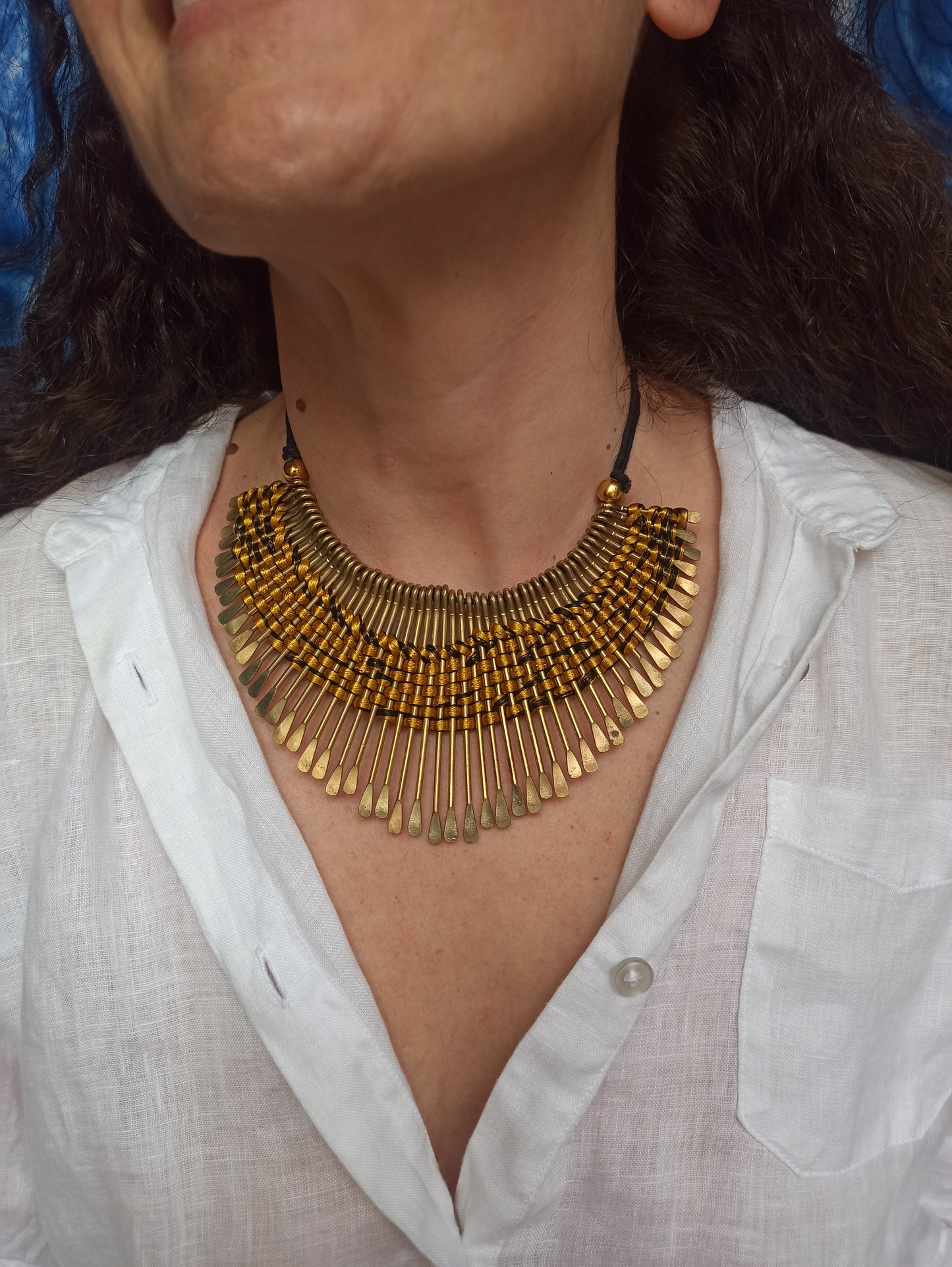 Golden bib necklace with colored threads