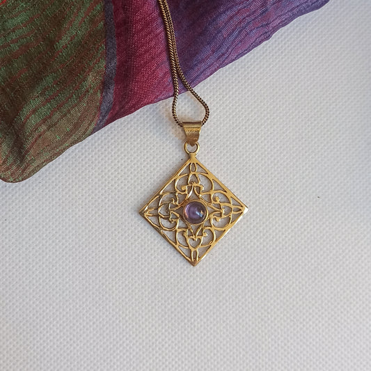 Golden necklace with purple rhombus pendant