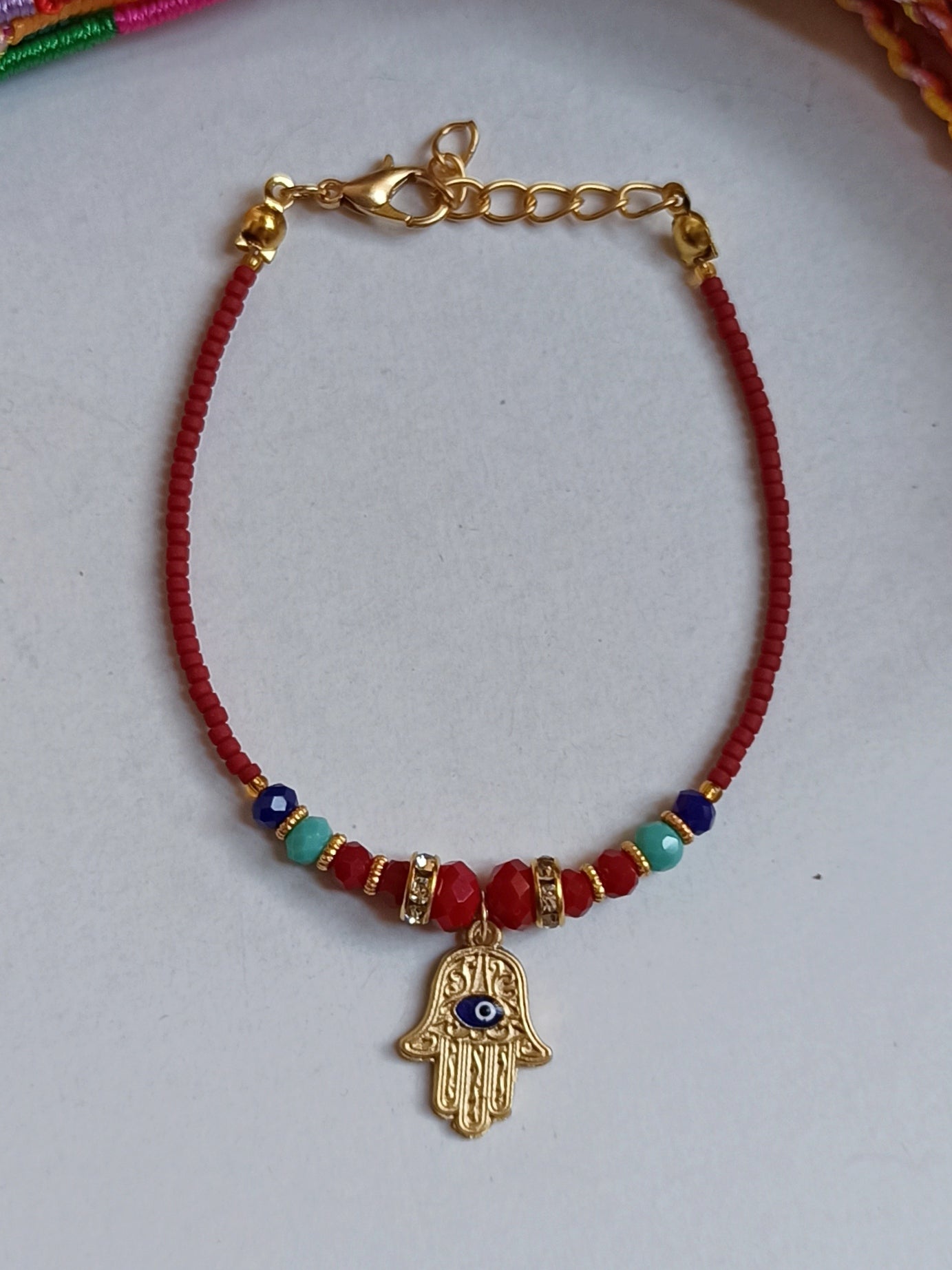 Dünnes rotes Armband mit der Hand der Fatima