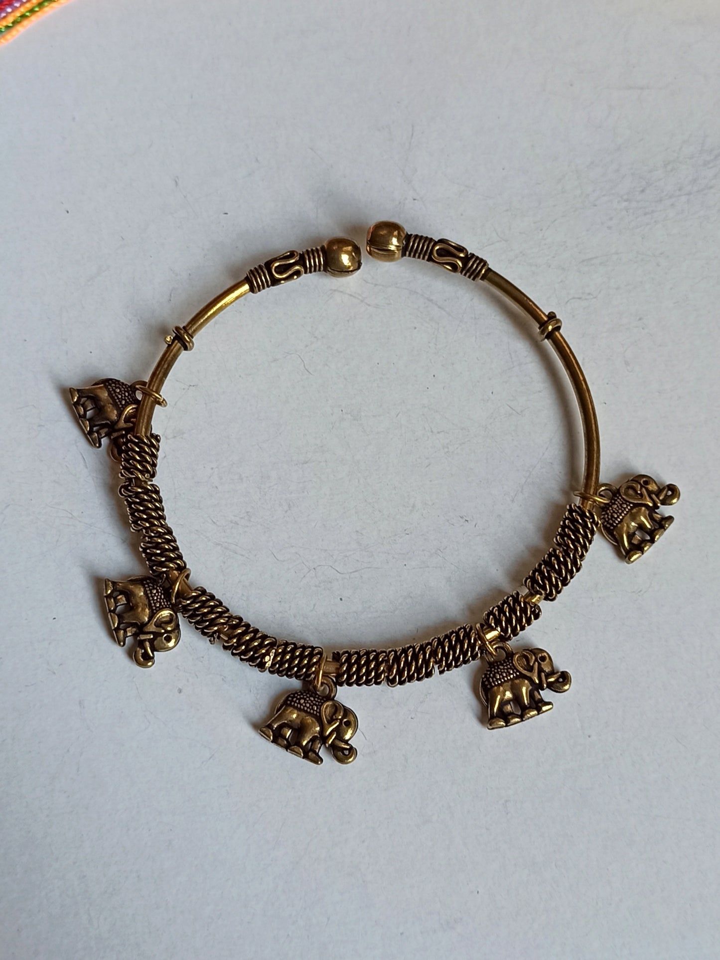 Thin golden bracelet with hanging elephants